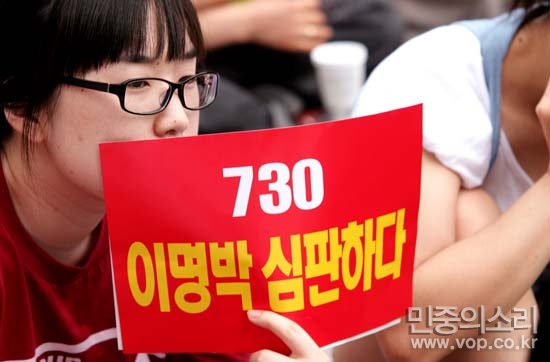 지난 5일 촛불문화제에 참석한 시민이 '7.30 이명박 심판하다'라는 피켓을 들고 있다.